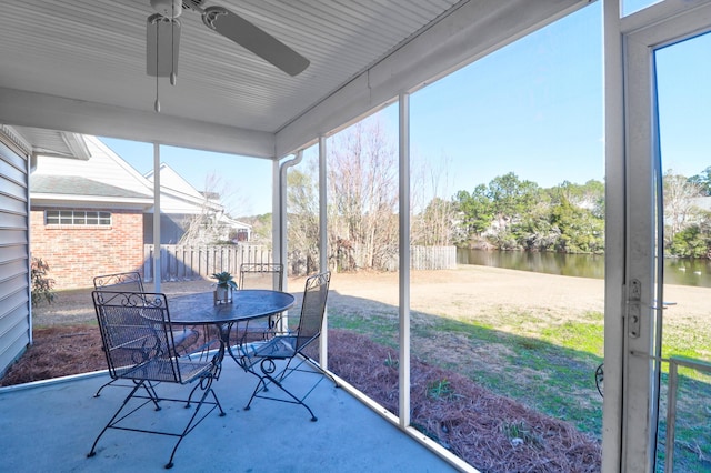 sunroom / solarium with a water view and ceiling fan