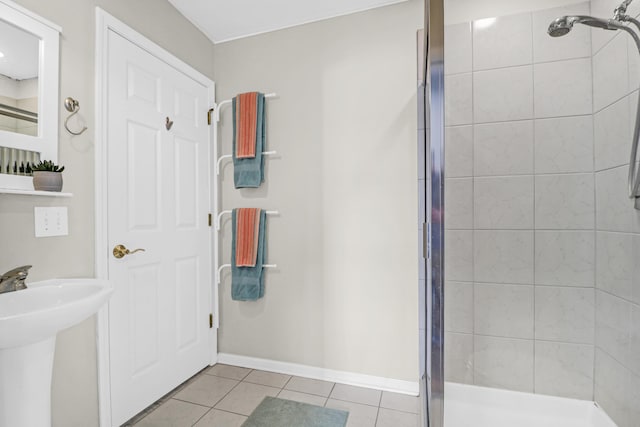 bathroom with sink, a shower with door, and tile patterned flooring