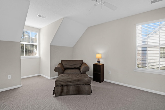 living area with ceiling fan, light carpet, and vaulted ceiling