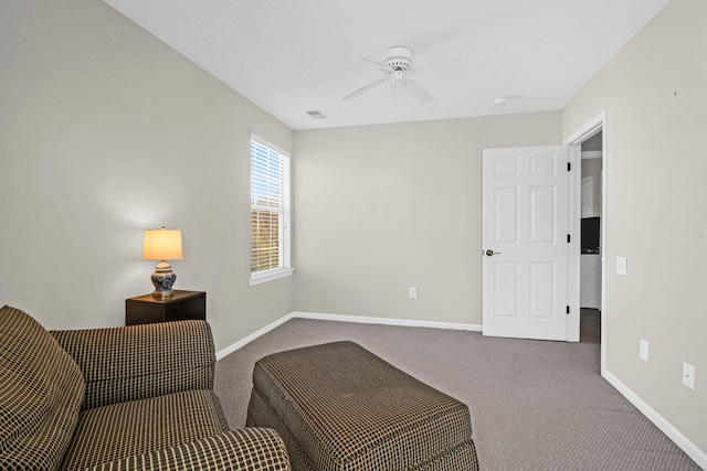 sitting room with ceiling fan and carpet flooring