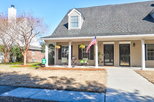 cape cod-style house with covered porch