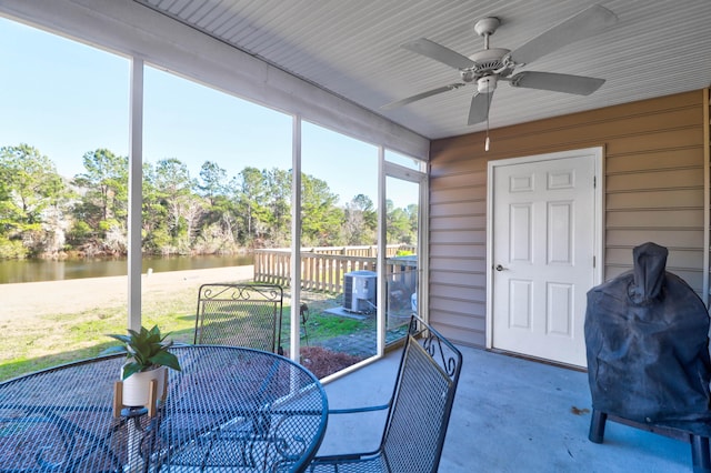 sunroom / solarium with a water view and ceiling fan