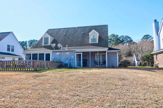 rear view of property featuring a lawn and central AC