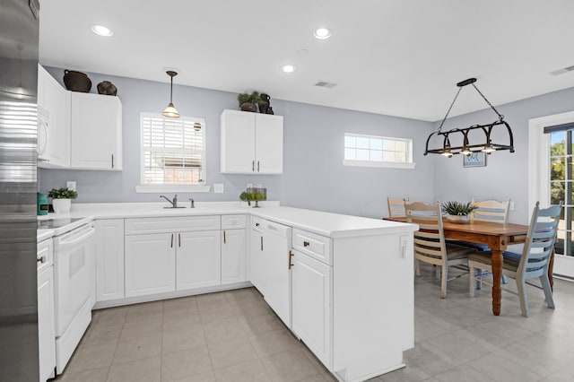 kitchen featuring kitchen peninsula, white appliances, pendant lighting, white cabinets, and sink