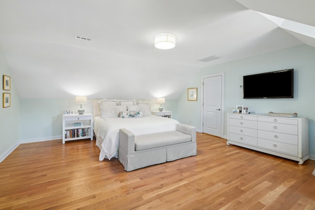 bedroom with vaulted ceiling and light hardwood / wood-style floors