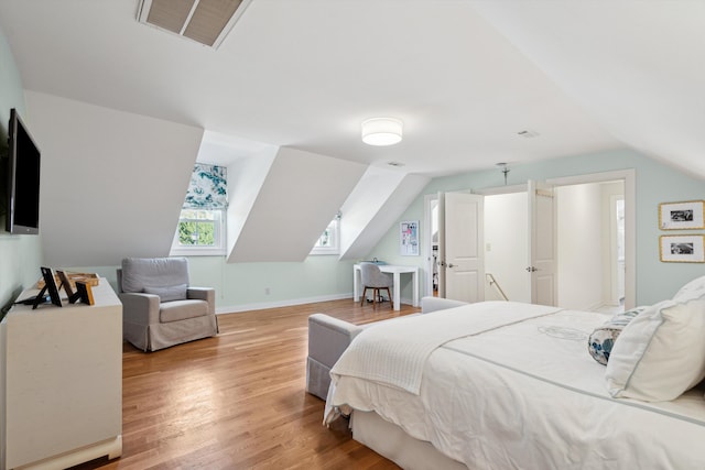 bedroom featuring vaulted ceiling and light wood-type flooring