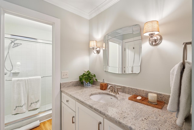 bathroom featuring ornamental molding, vanity, and walk in shower