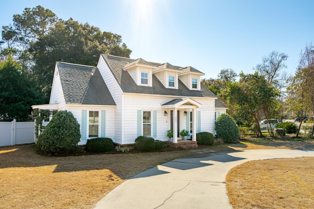 cape cod home with a front yard