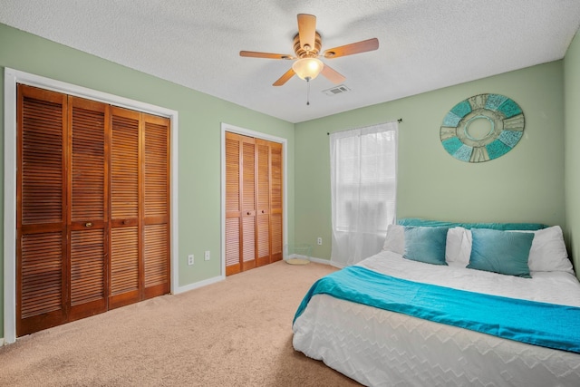 6231 Rolling Fork Rd Unit 1201-A, North Charleston, SC 29406 - carpeted bedroom with two closets, baseboards, a textured ceiling, and a ceiling fan
