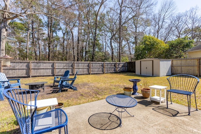 view of yard featuring an outbuilding, a patio area, a storage shed, and a fenced backyard