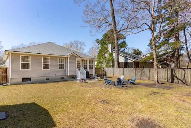 rear view of house featuring an outdoor fire pit, a yard, a fenced backyard, a shingled roof, and entry steps