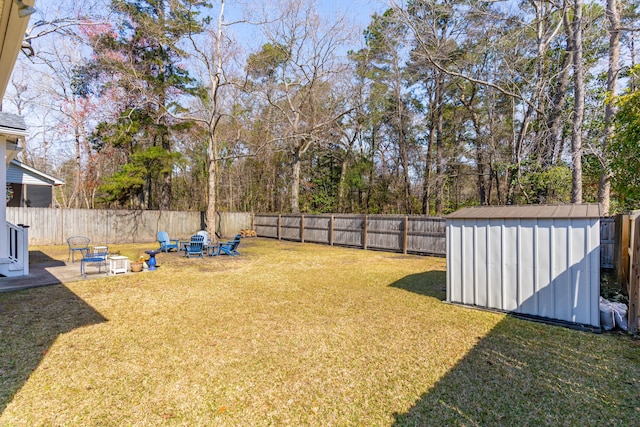 view of yard with an outbuilding, a storage shed, and a fenced backyard