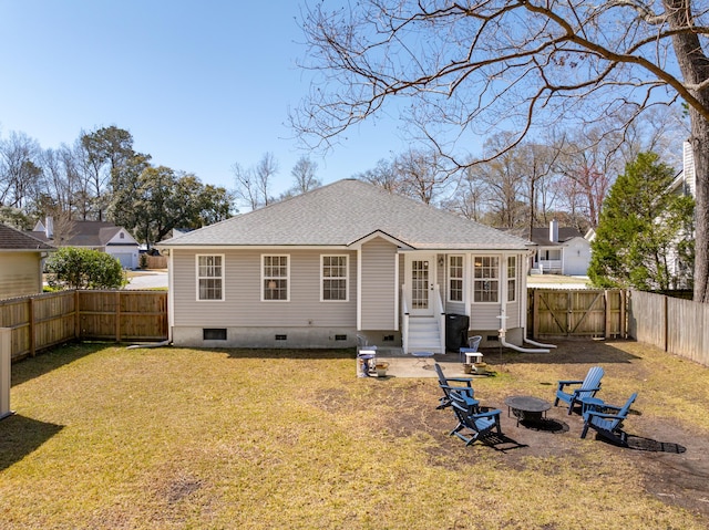 rear view of house with entry steps, an outdoor fire pit, a lawn, a fenced backyard, and crawl space