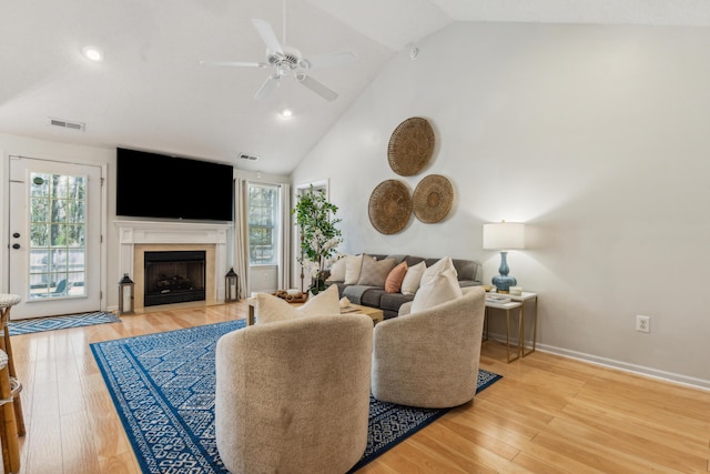 living room featuring visible vents, light wood-style floors, and a ceiling fan