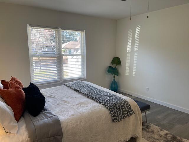 bedroom featuring dark hardwood / wood-style floors and multiple windows