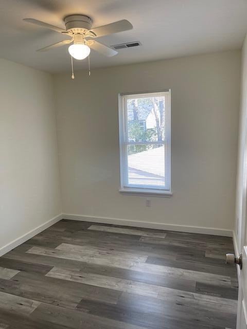 unfurnished room with ceiling fan and dark hardwood / wood-style flooring