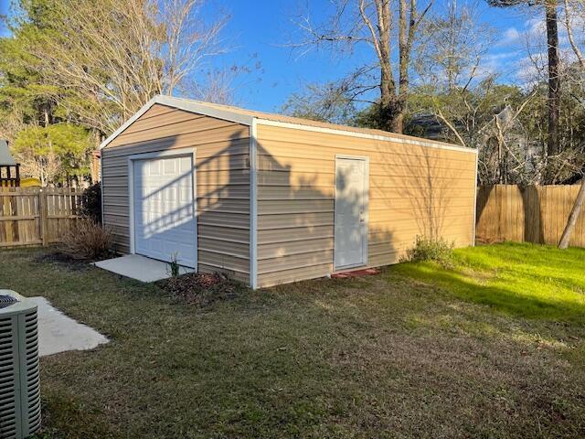 view of outbuilding featuring central AC unit and a yard