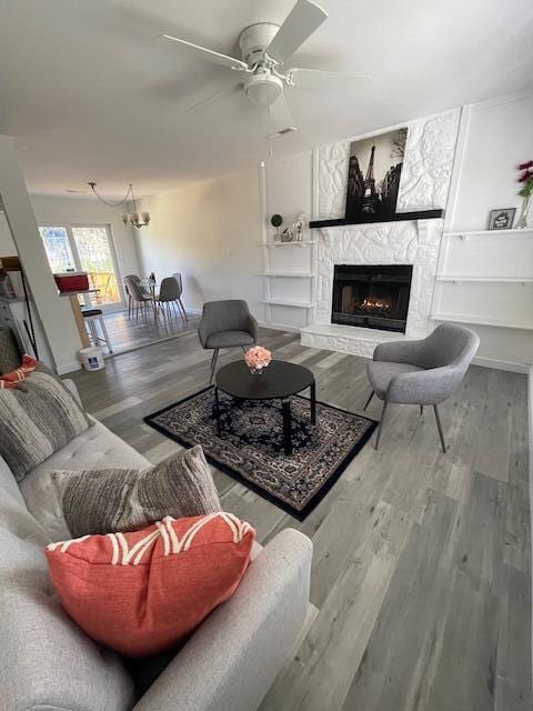 living room featuring ceiling fan, a fireplace, and hardwood / wood-style flooring