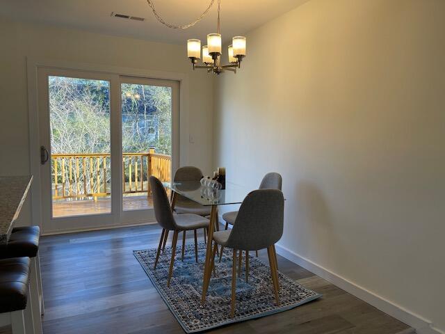 dining space featuring dark hardwood / wood-style flooring and a notable chandelier