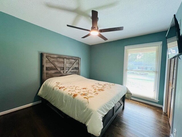 bedroom featuring ceiling fan, a textured ceiling, and dark hardwood / wood-style flooring