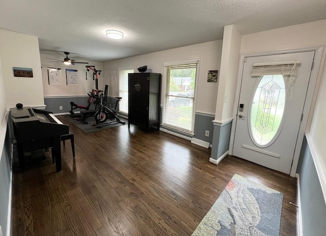 foyer featuring ceiling fan, a textured ceiling, and dark hardwood / wood-style flooring