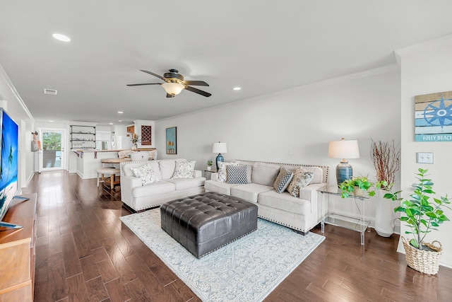 living room with crown molding, ceiling fan, baseboards, dark wood finished floors, and recessed lighting