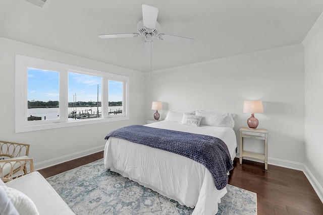 bedroom featuring baseboards, ornamental molding, wood finished floors, a water view, and ceiling fan