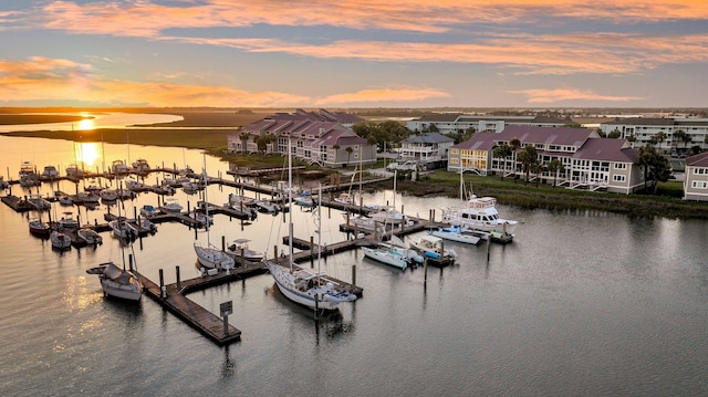 aerial view at dusk of a water view and view of marina