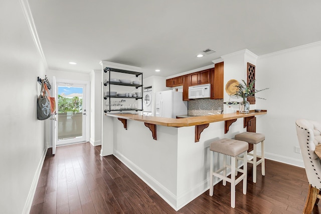 kitchen with white appliances, butcher block counters, baseboards, backsplash, and crown molding