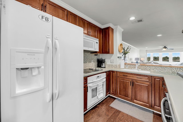 kitchen with white appliances, a sink, light countertops, backsplash, and recessed lighting