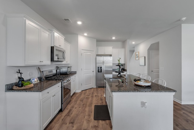 411 Bering Ln, Summerville, SC 29486 - kitchen featuring stainless steel appliances, a sink, wood finished floors, a center island with sink, and white cabinetry
