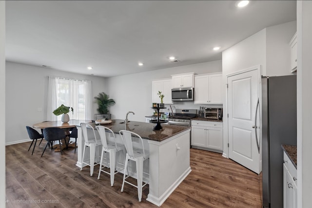411 Bering Ln, Summerville, SC 29486 - kitchen featuring appliances with stainless steel finishes, dark wood-style floors, white cabinetry, dark stone countertops, and recessed lighting