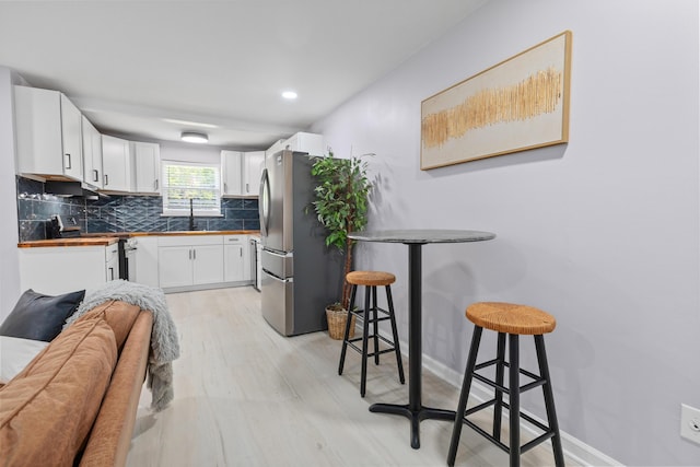 867 Colony Dr Unit F92, Charleston, SC 29407 - kitchen with appliances with stainless steel finishes, a sink, tasteful backsplash, light wood-style floors, and white cabinets