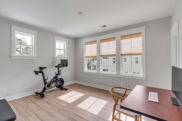 exercise area featuring baseboards, visible vents, and light wood-type flooring