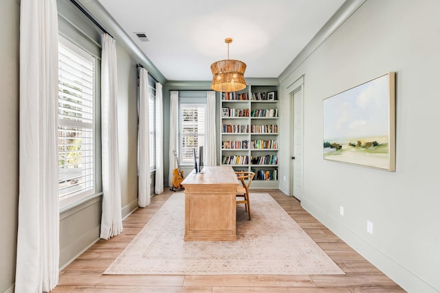 office space with wood finished floors, visible vents, and baseboards