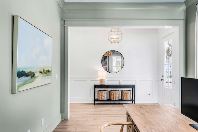 entryway with wood finished floors and a decorative wall