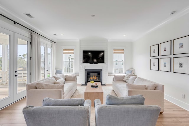 living area with light wood finished floors, visible vents, baseboards, recessed lighting, and a fireplace