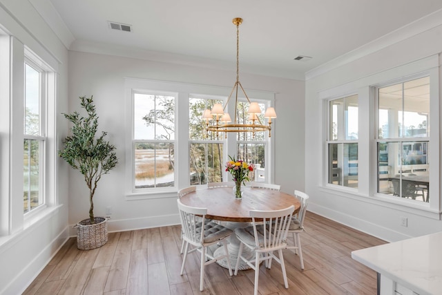 dining space with light wood finished floors, visible vents, baseboards, and ornamental molding