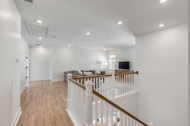 hall with baseboards, attic access, an upstairs landing, recessed lighting, and light wood-style flooring