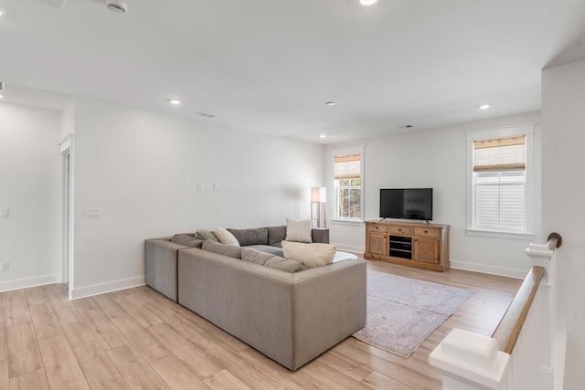 living room with recessed lighting, baseboards, and light wood-style floors