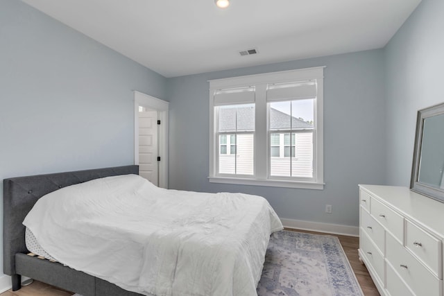 bedroom featuring visible vents, baseboards, and dark wood-type flooring