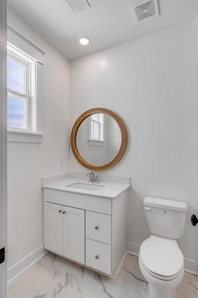 half bathroom featuring visible vents, marble finish floor, toilet, and baseboards