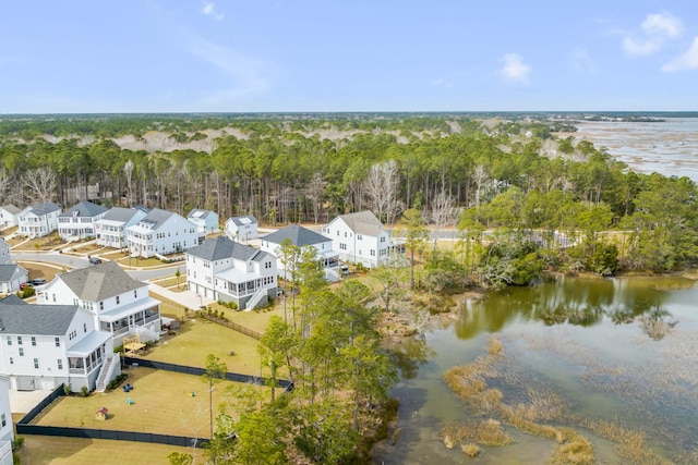 birds eye view of property featuring a forest view, a water view, and a residential view