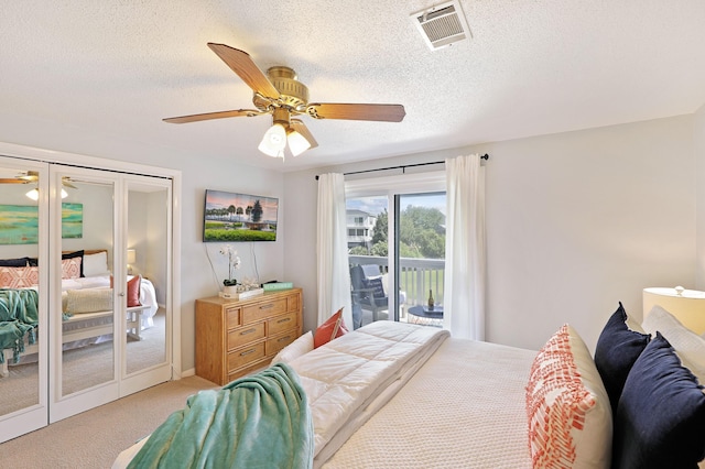 carpeted bedroom featuring access to exterior, visible vents, french doors, and a textured ceiling