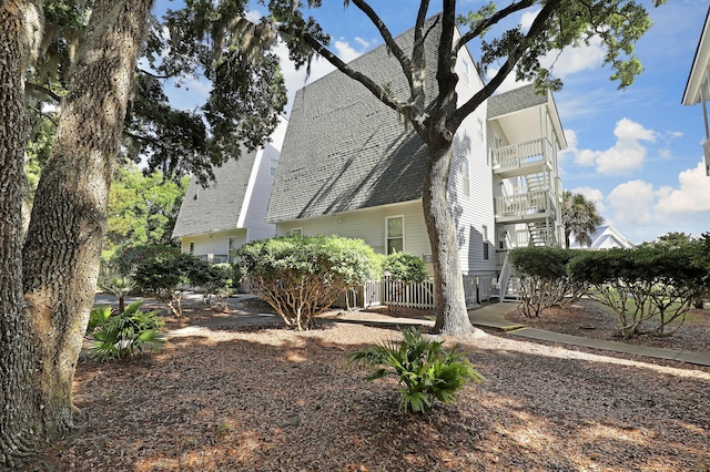 view of side of home with roof with shingles