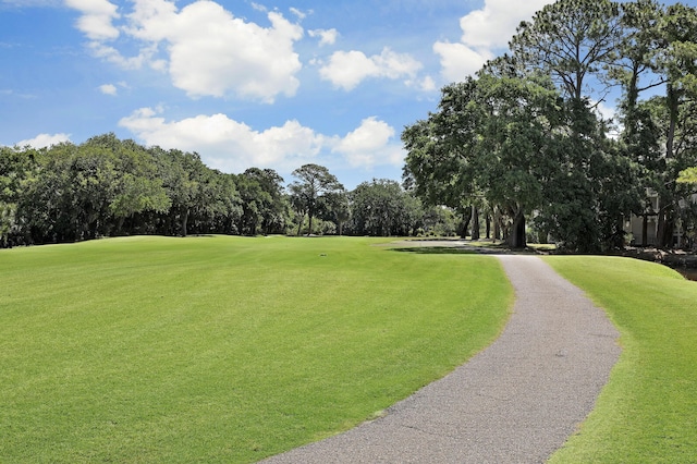 view of property's community featuring a yard and view of golf course