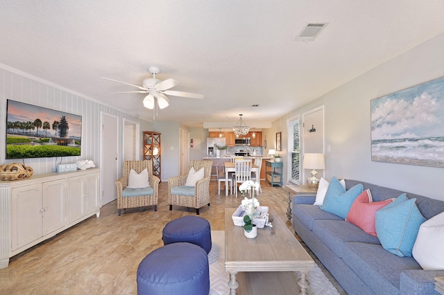 living room with ceiling fan with notable chandelier and visible vents