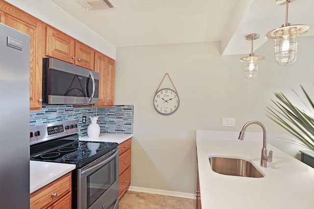 kitchen featuring visible vents, backsplash, light countertops, appliances with stainless steel finishes, and a sink