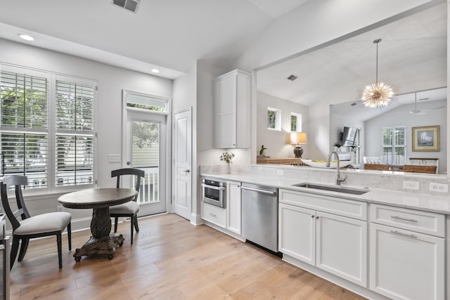 116 Cartright St, Daniel Island, SC 29492 - kitchen with stainless steel appliances, vaulted ceiling, white cabinetry, light wood-type flooring, and recessed lighting