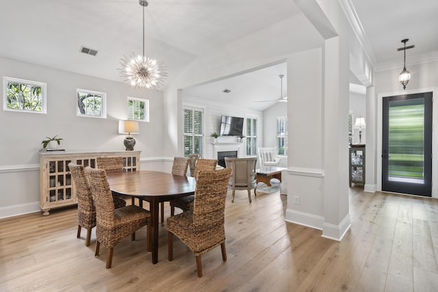 116 Cartright St, Daniel Island, SC 29492 - dining room with lofted ceiling, light wood finished floors, a fireplace, crown molding, and a chandelier